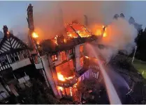  ??  ?? > The manor house as it went up in flames in 2014