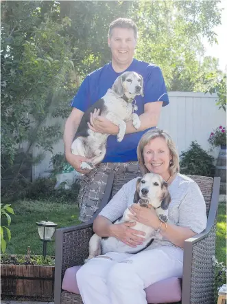  ?? ADRIAN SHELLARD ?? Tim and Jane Power are joined by their beagles Zak and Shiloh in the backyard of their Calgary home on Tuesday. The couple has fostered 18 dogs over the past few years.
