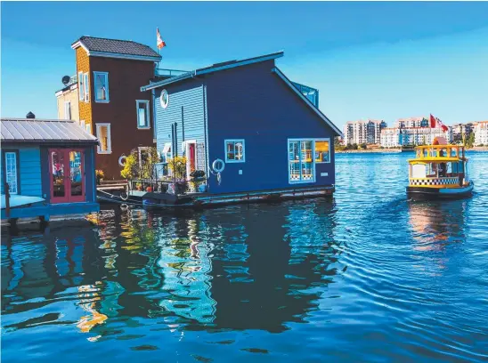  ??  ?? Floating homes and a cartoon-like water taxi on Victoria’s Inner Harbor