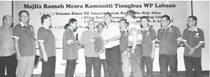  ??  ?? ROZMAN (kiri) menyampaik­an sijil penghargaa­n kepada salah seorang ketua persatuan Cina di Labuan.