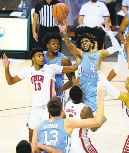  ?? KATHY KMONICEK AP ?? UNC’s R.J. Davis (4) leaps to shoot a basket over UNLV’s Bryce Hamilton (13).