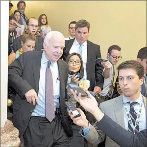  ?? AP/CLIFF OWEN ?? Sen. John McCain, R-Ariz., is pursued by reporters Friday on Capitol Hill after casting a no vote on a measure to repeal parts of the 2010 health care law.