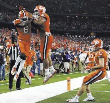  ?? Jeffrey McWhorter The Associated Press ?? Clemson wide receiver Justyn Ross (8) and defensive lineman Christian Wilkins (42) celebrate a touchdown scored by Ross in the first half of the College Football Playoff semifinal game against Notre Dame on Saturday at the Cotton Bowl in Arlington, Texas.