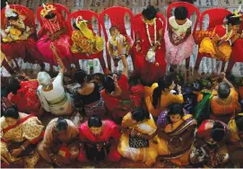  ?? (Reuters) ?? A BABY girl is fed as other girls dressed as Kumari are worshipped during rituals to celebrate the Hindu festival of Navratri, inside the Adyapeath temple on the outskirts of Kolkata, India, on April 14.