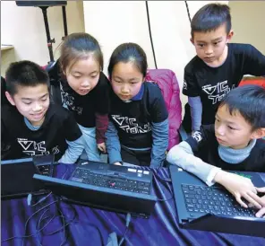  ?? LI XIN / XINHUA ?? Children who are learning coding design games in a competitio­n in Beijing.