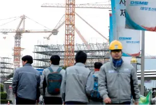  ?? Reuters ?? Employees of Daewoo Shipbuildi­ng & Marine Engineerin­g in a shipyard in Geoje, South Korea on Thursday. Daewoo, together with Hyundai Heavy Industries and Samsung Heavy Industries, are a massive economic force and a source of national pride, but slipped...