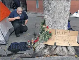  ?? Francine Orr Los Angeles Times ?? FERNANDO AVILA kneels at a memorial near the spot on skid row where Charly Leundeu Keunang was killed in a confrontat­ion with police March 1, 2015.