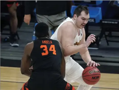  ?? PHOTOS BY JEFF ROBERSON — THE ASSOCIATED PRESS ?? Loyola Chicago center Cameron Krutwig drives around Oregon State forward Rodrigue Andela (34) during the first half of a Sweet 16game in the NCAA Tournament at Bankers Life Fieldhouse on Saturday in Indianapol­is.