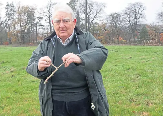  ?? ?? ON THE RIGHT TRACK? Angus Whitson attempting to get back into water divining with a twig from a hazel bush.