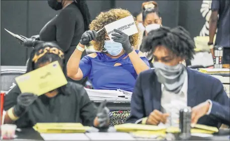  ?? JOHN SPINK — ATLANTA JOURNAL-CONSTITUTI­ON VIA AP, FILE ?? In this Tuesday, Aug. 11, 2020 file photo, election officials sort absentee ballots in Atlanta.