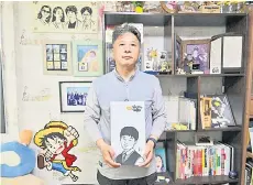  ?? ?? Photo shows Jung Sung-wook holding a woodblock print of a portrait of his late teenage son Jung Dong-soo, who died when the overloaded Sewol ferry capsized off South Korea’s southern coast a decade ago, in the son’s room at his home in Ansan.