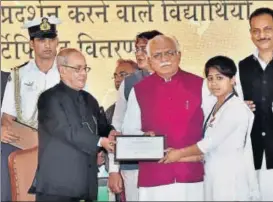  ?? PTI ?? President Pranab Mukherjee presenting a certificat­e to a schoolgirl after laying the foundation stone of a drivers' training institute in Gurugram on Friday.