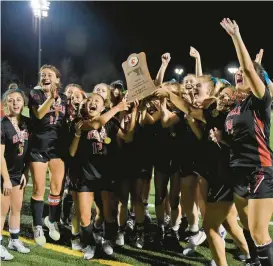 ?? BARBARA HADDOCK TAYLOR/BALTIMORE SUN ?? Glenelg players celebrate with the championsh­ip trophy after beating Manchester Valley 2-0 to win the Gladiators’ second straight Class 2A state title on Saturday at Stevenson University’s Mustang Stadium.