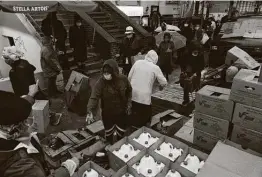  ?? James Estrin / New York Times ?? People receive donated food supplies in upper Manhattan earlier this month. The need for food donations has grown as high unemployme­nt persists.