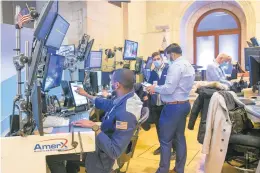  ?? TED SHAFFREY/AP ?? Traders work on the New York Stock Exchange floor in New York on Tuesday during another volatile day of trading.