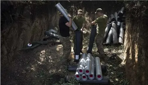  ?? ?? Ukrainian servicemen prepare ammunition before firing towards Russian positions near Bakhmut, Ukraine, July 7, 2023.