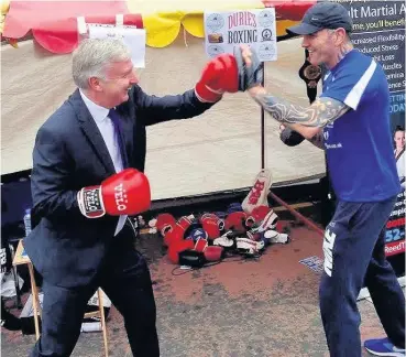  ??  ?? Boxing clever James Kelly MSP is put through his paces by Archie Durie at the Durie’s Boxing Club stall at Cambuslang Summerfest