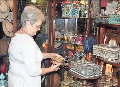  ?? Doug Walker / Rome News-Tribune ?? Rome News-Tribune SUNDAY, Christa Grant looks over a piece of handmade jewelry in Christa’s etc., her antique boutique of 30 years at 10 Alabama St. in Cave Spring.