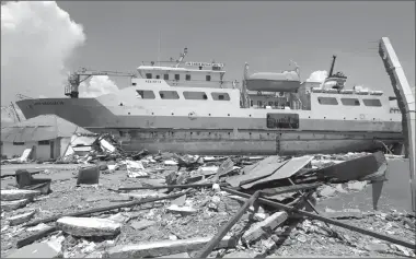  ?? Associated Press photo ?? A ship rests on land after it was swept ashore during Friday’s tsunami at a neighbourh­ood in Donggala, Central Sulawesi, Indonesia, Tuesday. A magnitude 7.5 earthquake struck at dusk on Friday, generating the tsunami said to have been as high as six metres (20 feet) in places.