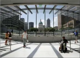  ?? JEFF ROBERSON — THE ASSOCIATED PRESS ?? In this file photo, visitors use a new entrance to the Gateway Arch as the Old Courthouse and the rest of downtown are seen through its windows in St. Louis. A newly expanded museum underneath the Arch is set to be open on July 3 and is the final piece...