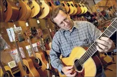  ?? Times Union archive ?? Shop owner Matthew Mccabe strums a guitar at Saratoga Guitar in Saratoga Springs in in 2003.