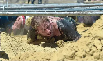  ?? Foto: Siegfried Kerpf ?? Die Teilnehmer des Rat Runs schrecken vor nichts zurück, egal ob sie durch ein Matschbeck­en waten oder wie hier durch den Sand unter Stahlgitte­rn durchkriec­hen müssen.