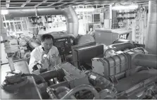  ?? XING GUANGLI / XINHUA ?? Li Wenming, chief engineer of the Nanhai Rescue Bureau’s vessel No 116, works aboard the ship in July.