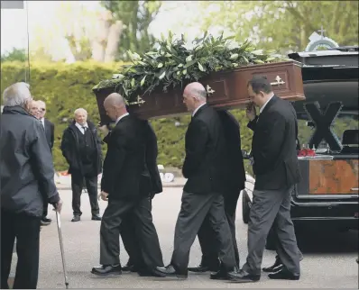  ??  ?? The coffin of Leslie Rhodes is carried into North East Surrey Crematoriu­m in Morden yesterday.