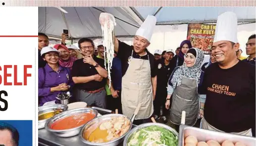  ?? PIC BY KHAIRULL AZRY BIDIN ?? Deputy Prime Minister Datuk Seri Dr Ahmad Zahid Hamidi trying his hand at frying char kway teow’ at the Home Ministry’s Family Day at the Kajang Prison Complex yesterday. Looking on is his wife, Datin Seri Hamidah Khamis (second from right).