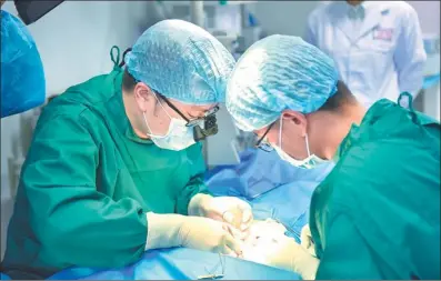  ?? PHOTOS PROVIDED TO CHINA DAILY ?? Scientists at Revotek, a Chengdu-headquarte­red biotech company, perform an animal experiment, using a 3-D printed vein transplant.