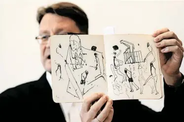  ?? MENAHEM KAHANA/GETTY-AFP ?? Stefan Litt, an archivist at Israel’s National Library, last week displays some drawings by novelist Franz Kafka.