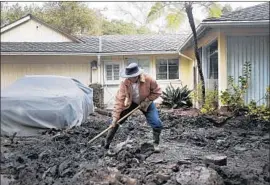  ?? Photograph­s by Katie Falkenberg Los Angeles Times ?? MARK VANCE shovels mud at his home in Montecito. His family is running out of food for their dog, but are afraid they won’t be able to return if they leave.