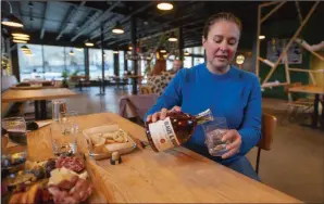  ?? (NWA Democrat-Gazette/J.T. Wampler) ?? Cara Blaize Osborne pours a glass of Blaize & Brooks Homesick bourbon Tuesday at a Fayettevil­le restaurant. Osborne teaches entreprene­urship at the University of Arkansas.