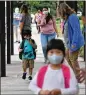  ?? HYOSUB SHIN/AJC FILE ?? Mask-wearing students arrive at Jackson Elementary School in Atlanta for the start of the school year on Aug. 26, 2020.