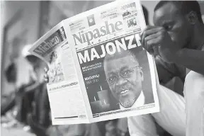  ?? — Gambar AFP ?? TIADA LAGI: Seorang lelaki membaca surat khabar yang melaporkan berita kematian Magufuli di muka depannya di Dar Es Salaam semalam.