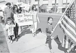  ?? THOMAS HAWTHONRE/ THE REPUBLIC ?? Son Mimyi Cao, 4, (left) marches with his mother Cathy Huang (right), Ji Wu (second from right), and Wu’s daughter Sunan Zhang, 6, against the recent conviction of New York police officer Peter Liang outside of the Arizona state Capitol at Bolin Park...