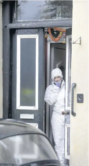  ??  ?? INVESTIGAT­ION Forensic officer leaves house yesterday. Pic: James Chapelard/SWNS.com