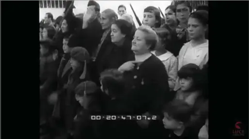  ??  ?? Niños vestidos de requetés realizan el saludo militar mientras una niña y una anciana hacen el saludo fascista mientras pasa el Gran Poder.