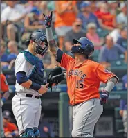  ?? Associated Press ?? Going yard: Houston Astros catcher Martin Maldonado, right, points to the sky as he crosses home plate in front of Seattle Mariners catcher Mike Zunino after his solo home run in the fifth inning of a baseball game Wednesday in Seattle. The Astros topped the Mariners 10-7.