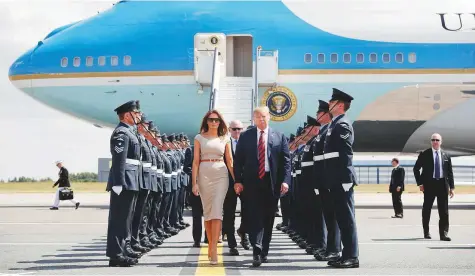  ?? AP ?? US President Donald Trump and First Lady Melania Trump walk across the tarmac after stepping off Air Force One as they arrive at London’s Stansted Airport yesterday. Walking directly behind them is Woody Johnson, US Ambassador to the UK.