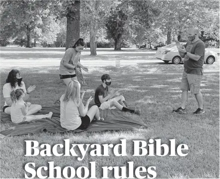  ?? [CARLA HINTON PHOTOS/ THE OKLAHOMAN] ?? Daniel Sorrells, at right, leads a song during a Backyard Bible School session on his Edmond lawn.