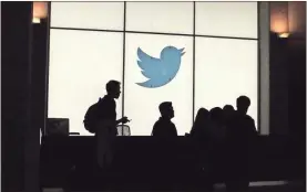  ?? Glenn Chapman/AFP/Getty Images North America/TNS ?? Employees walk past a lighted Twitter logo as they leave the company’s headquarte­rs in San Francisco in August 2019.