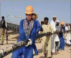  ??  ?? Chinese and Pakistani workers work on the constructi­on of a solar power station in Punjab, Pakistan. (COURTESY OF MCC)