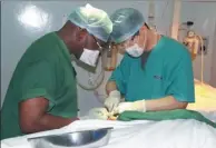  ??  ?? Zhai performs surgery with a Zambian doctor at the Maina Soko Military Hospital.