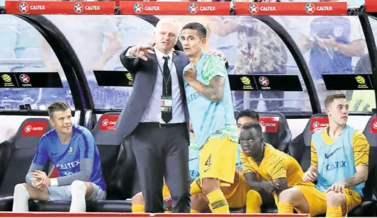  ?? Cup. GETTY IMAGES ?? Testing times: Australian Head Coach Graham Arnold with Tim Cahill during the Internatio­nal friendly match between the Australian Socceroos and Lebanon at the ANZ Stadium on November 20, 2018 in Sydney, Australia. Cahill has since retired and Arnold’s team is facing injury concerns as it heads to Abu Dhabi to defend the Asian