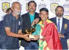  ?? ?? Top goal scorer of the tournament A.F.M. Arham of Hameed Al Husseinie, receiving the Golden Boot from M. Ismail, former national player and Renown Football Academy Coach