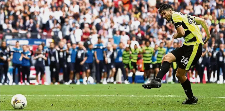  ?? Reuters ?? Millions on the line: Christophe­r Schindler coolly slotting home to help Huddersfie­ld win 4-3 in the penalty shootout against Reading in the Championsh­ip playoff final at Wembley on Monday. —