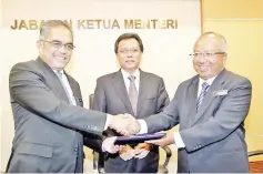  ??  ?? Shafie (centre) witnessing the instrument of office handover ceremony from outgoing State Secretary Sukarti (left) to his successor Hashim at the State Administra­tive Centre in Likas.