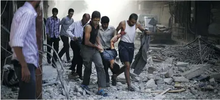  ?? SAMEER AL-DOUMY/AFP/GETTY IMAGES ?? Syrians carry a wounded man after airstrikes by Syrian government forces on rebel-held Douma on Friday.