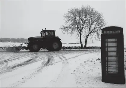  ?? PICTURE: REUTERS ?? A tractor with a snow plough clears the A515 near Buxton in Britain yesterday.